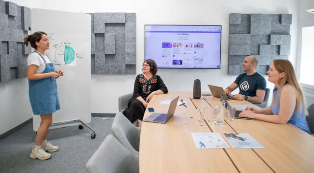 Team collaborating during a meeting with presentation and discussion in a modern office. Entry-level SEO jobs and the details that decide it