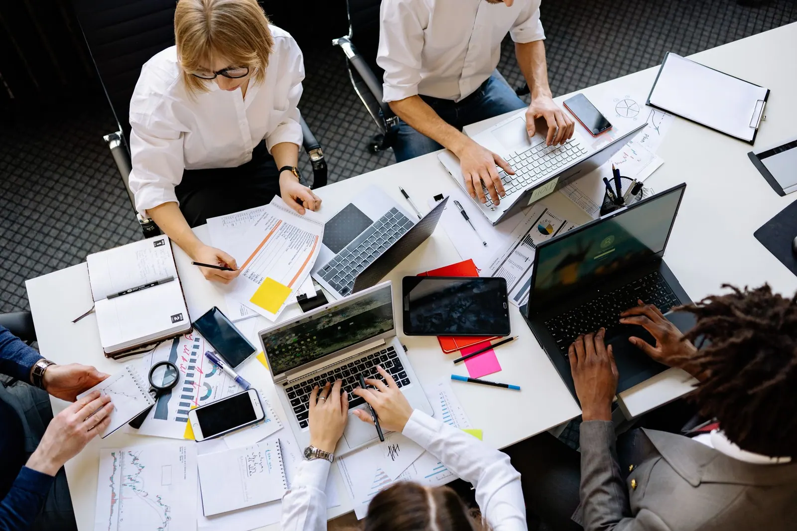 Vibrant office teamwork scene with laptops, documents, and diverse professionals in a meeting. The practical 2027 guide to market research careers