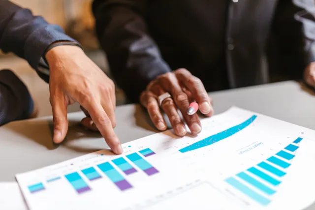 Business professionals analyzing charts and graphs during a meeting. Marketing analytics salary: place a role by level and stack