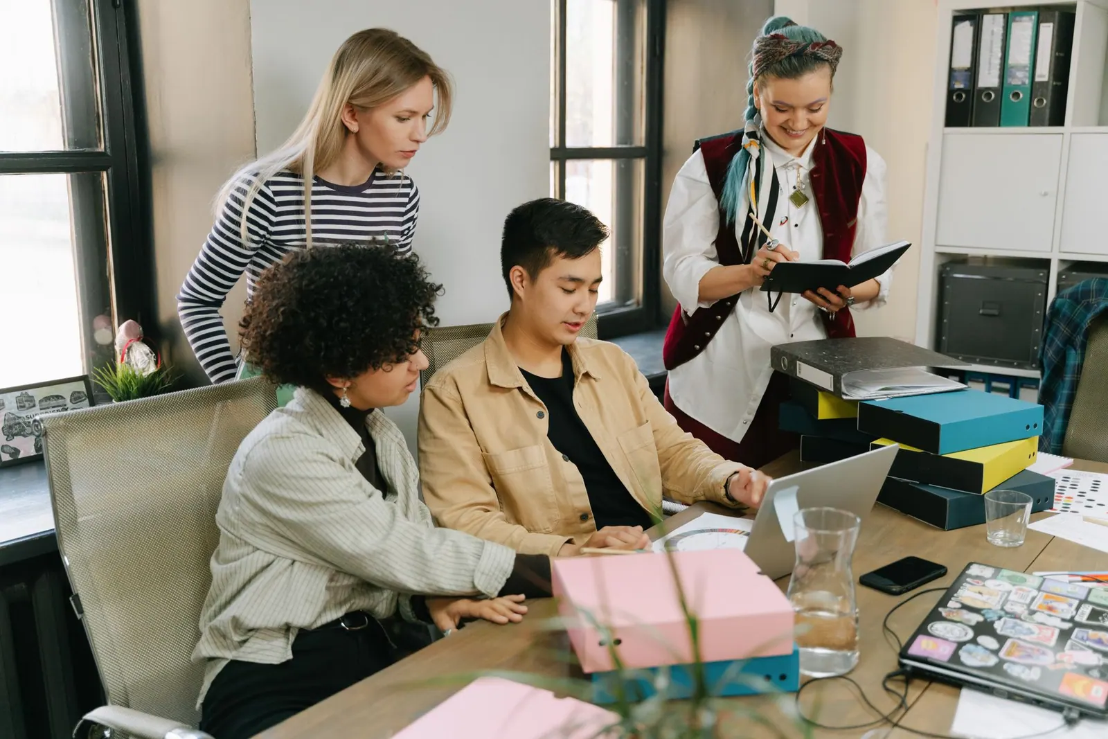 A group of young professionals engaging in a collaborative meeting in a modern office setting. Product marketing careers: a practical guide for 2027