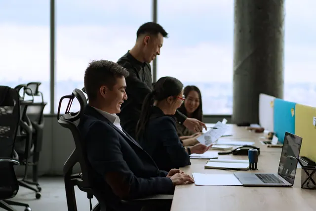 Group of coworkers in a modern office having a collaborative discussion. Professional and lively setting. SEO careers explained for business teams in 2027
